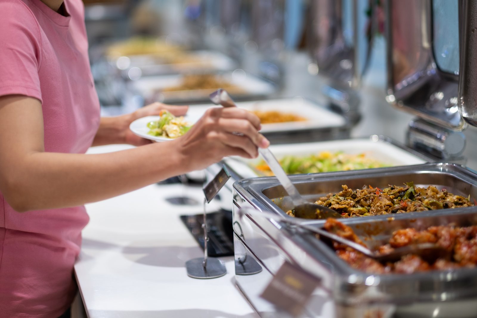 Una persona sirviéndose sola en un buffet, sin depender de un mesero.